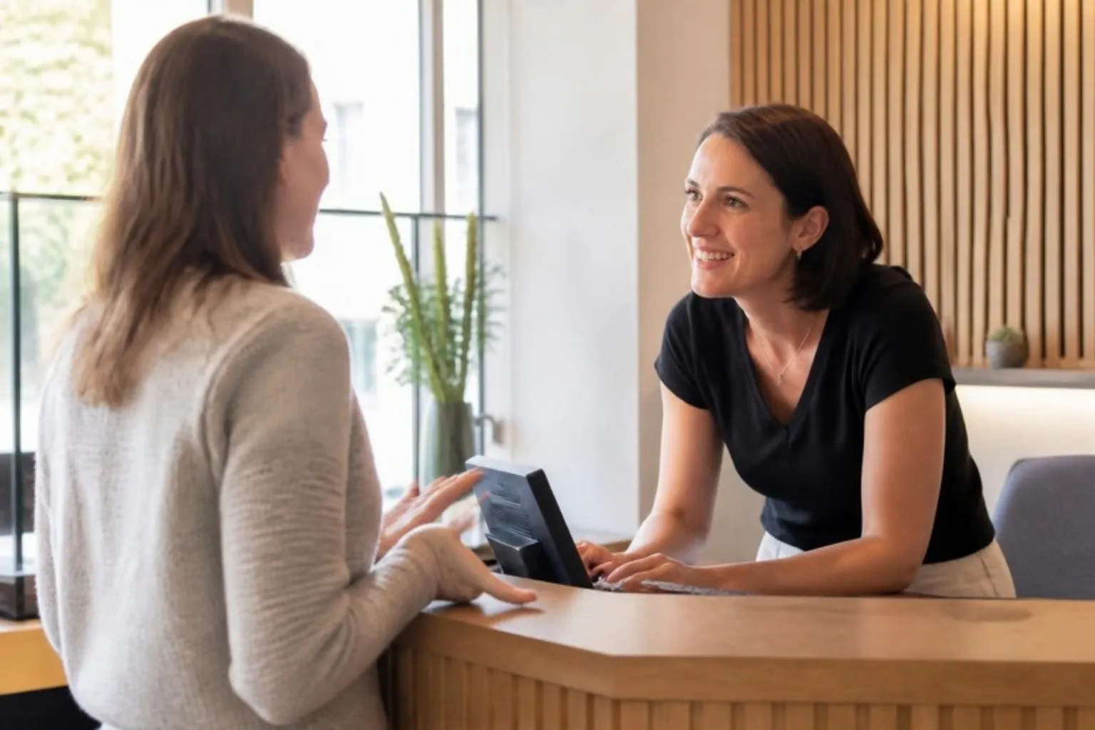 A staff member listening attentively to a customer at a reception desk
